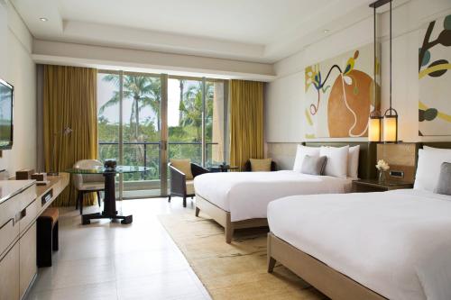 a hotel room with two beds and a desk at Renaissance Sanya Haitang Bay Resort in Sanya