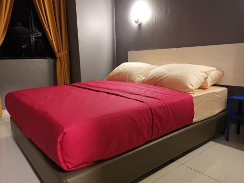 een bed met een rode deken erop bij Belle Vue 408 Genting View Resort in Genting Highlands