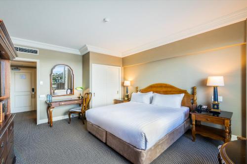 a hotel room with a bed and a desk at Stamford Plaza Brisbane in Brisbane