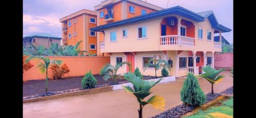 une grande maison orange et bleue dans l'établissement The Massango Guesthouse Limbe-Victoria Cameroon, à Limbe