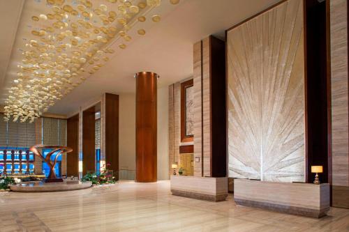 a lobby with a sculpture in the middle of a building at Sheraton Bailuhu Resort, Huizhou in Huizhou