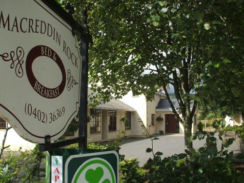 a sign in front of a house with a driveway at Macreddin Rock Bed & Breakfast in Aughrim