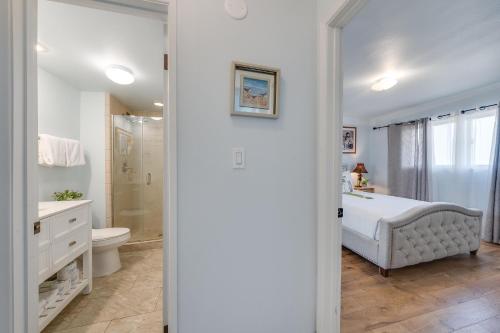 a white bathroom with a tub and a toilet at Menehune Shores 403 · MHS 403 Remodeled BeachFront 2BD Getaway in Kihei