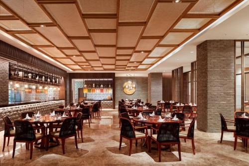 a restaurant with tables and chairs and a bar at Sheraton Zibo Hotel in Zibo