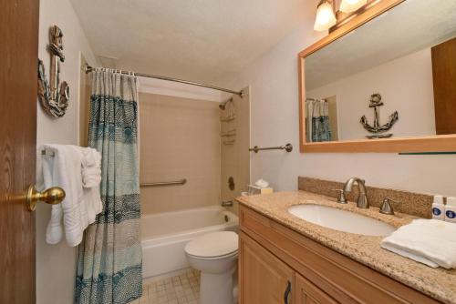 a bathroom with a sink and a tub and a toilet at Maalaea Banyans 203 in Wailuku