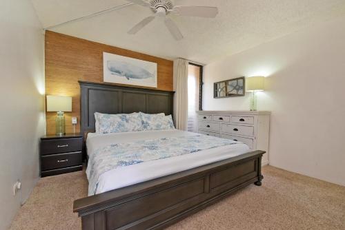 a bedroom with a large bed and a ceiling fan at Maalaea Banyans 203 in Wailuku