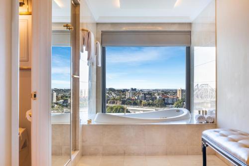 a bathroom with a large window with a bath tub at Stamford Plaza Brisbane in Brisbane