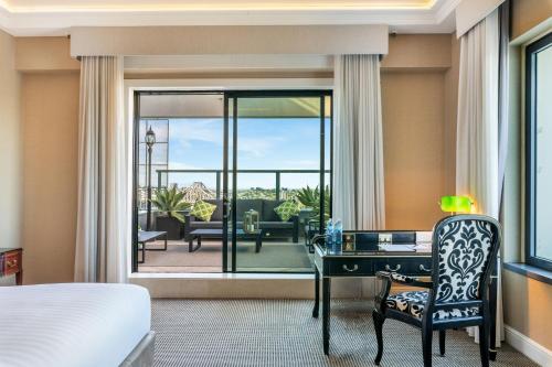 a bedroom with a bed and a desk and a view of a patio at Stamford Plaza Brisbane in Brisbane