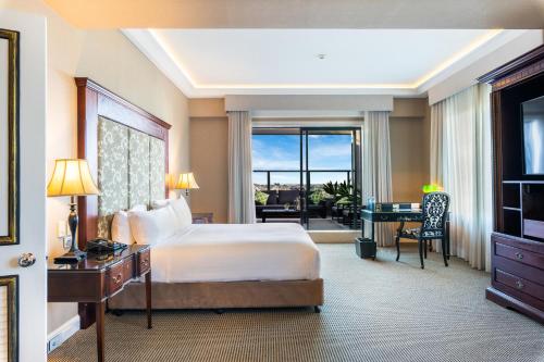 a hotel room with a bed and a desk and a bedroom at Stamford Plaza Brisbane in Brisbane