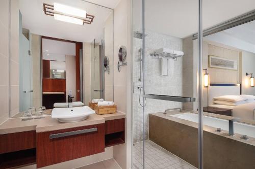 a bathroom with a sink and a shower and a tub at Courtyard by Marriott Wuxi Lihu Lake in Wuxi