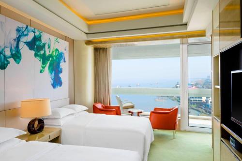 a hotel room with two beds and a large window at Sheraton Huzhou Taihu Lake Hot Spring Resort & Spa in Huzhou