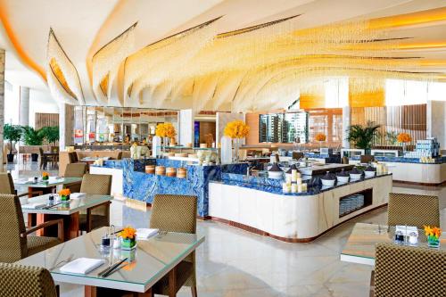 a restaurant with tables and chairs and a lobby at Sheraton Huzhou Taihu Lake Hot Spring Resort & Spa in Huzhou