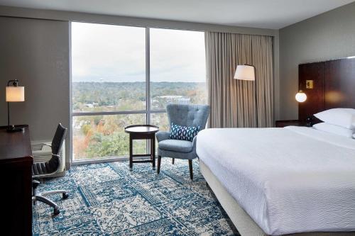 a hotel room with a bed and a large window at Four Points by Sheraton Tallahassee Downtown in Tallahassee