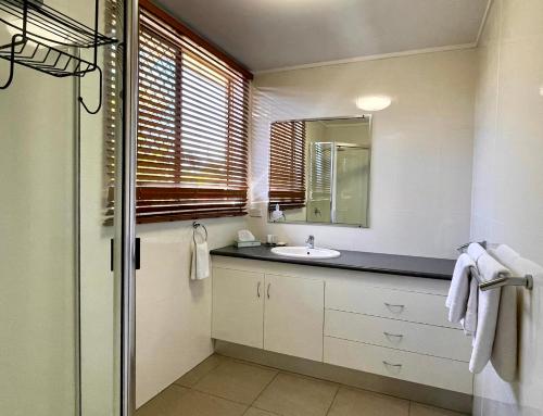 a bathroom with a sink and a mirror at Western Heritage Motor Inn in Moranbah