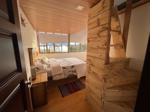 um quarto com uma cama e uma escada numa casa em Cabaña Valle De La Laguna em Aquitânia