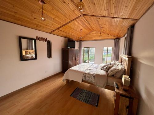 um quarto com uma cama e um tecto de madeira em Cabaña Valle De La Laguna em Aquitania