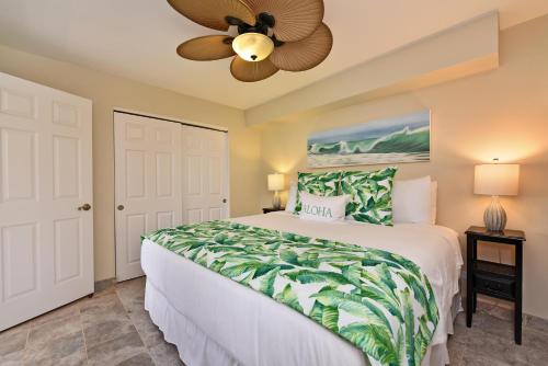 - une chambre avec un lit et un ventilateur de plafond dans l'établissement Kahana Villa E601, à Kahana