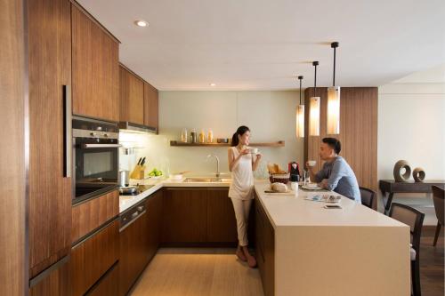 a man and a woman standing in a kitchen at Marriott Executive Apartments Tianjin TEDA in Binhai