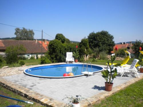 a swimming pool in a yard with two lawn chairs at Chalupa Tourov in Bavorov