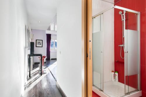 a bathroom with a shower and a red wall at Stay U-nique Apartments Rambla Catalunya IV in Barcelona