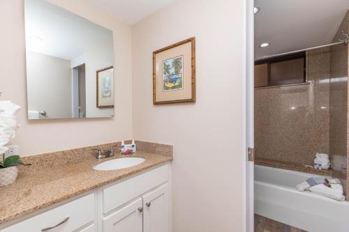 a bathroom with a sink and a tub and a mirror at Kaanapali Shores 527 in Kahana