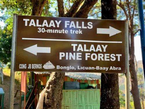 a brown sign with arrows on a tree at Layugan garden resort bucay abra in Bangued