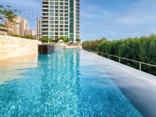a swimming pool with blue water and a tall building at Fairways Tower by Emaar, The Views and Greens in Dubai