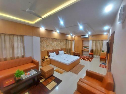 a living room with a bed and a couch at Hotel sunshine & restaurant in Pūrnia