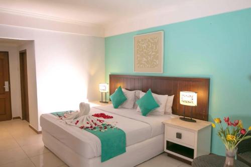 a bedroom with a large bed and a table with flowers at Kuta One Party Hotel in Kuta