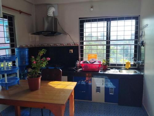 uma cozinha com uma mesa de madeira e um lavatório em Namaste Stay Apartment em Pokhara