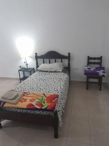 a bedroom with a bed and two tables and a chair at Alojamiento Temporario Sol de las Yungas in Libertador General San Martín