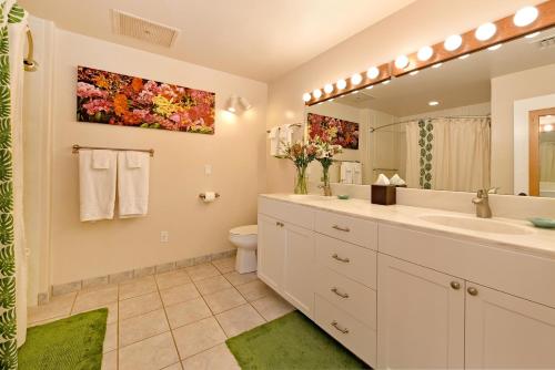 a bathroom with a sink and a toilet and a mirror at Kaanapali Royal N102 in Lahaina