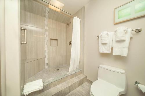 a white bathroom with a shower and a toilet at Kaanapali Royal B303 in Lahaina