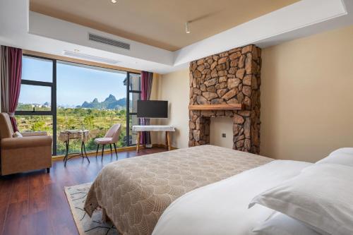 een slaapkamer met een groot bed en een open haard bij Guilin Village Creek Inn in Guilin