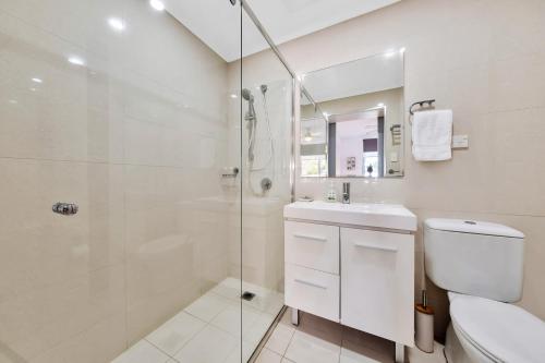 biała łazienka z toaletą i prysznicem w obiekcie Luxe Pelican Lake w mieście The Entrance