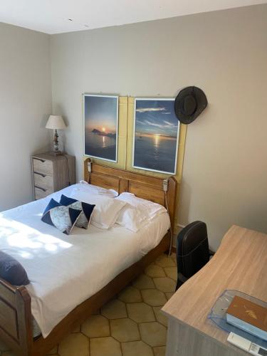 ein Schlafzimmer mit einem großen Bett und zwei Fenstern in der Unterkunft Villa Marie Cap Corse sentier douaniers in Centuri