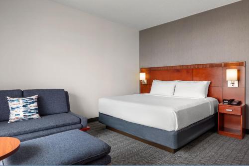 um quarto de hotel com uma cama e uma cadeira em Courtyard by Marriott Minneapolis-St. Paul Airport em Mendota Heights