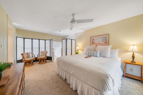 um quarto com uma grande cama branca e janelas em Koa Resort 3J em Kihei