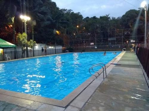 a large swimming pool at night with people in it at Acogedor Apartamento Urbanización Tricentenario in Medellín