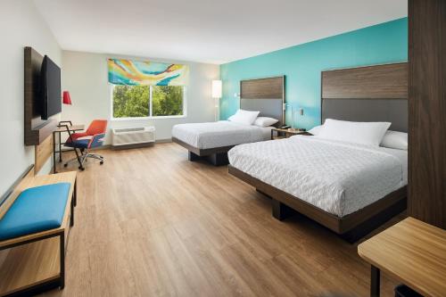 a hotel room with two beds and a desk at Tru By Hilton Charleston Airport in Charleston