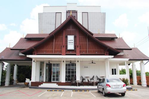 a building with a car parked in a parking lot at Luckswan Boutique Chiang Rai - SHA Extra Plus in Chiang Rai