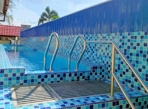 a blue tiled swimming pool with a ramp in it at Seri Ibai Permai in Kuala Terengganu