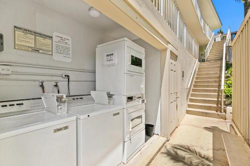 a kitchen with white appliances and a staircase at Keawakapu 208 in Wailea