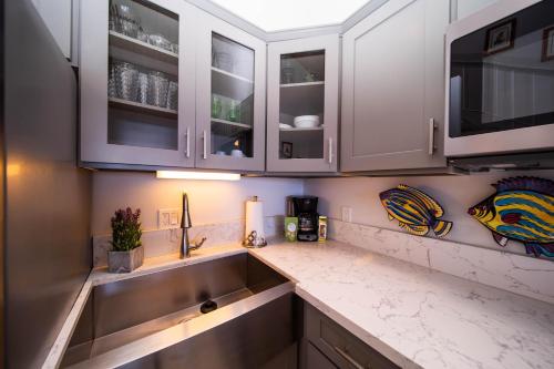 a kitchen with white cabinets and a sink at Kulakane 306 in Kahana