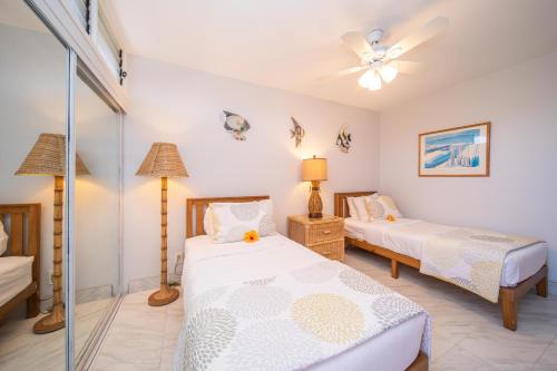 - une chambre avec 2 lits et un ventilateur de plafond dans l'établissement Kulakane 306, à Kahana
