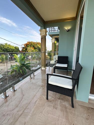 a porch with two chairs and a table on a balcony at Villa Panorama in Montego Bay