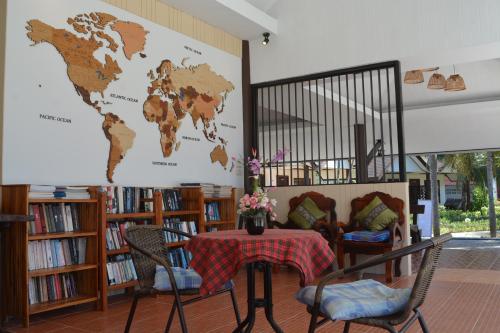 a table in a library with a world map on the wall at Lanta IL Mare Beach Resort in Ko Lanta
