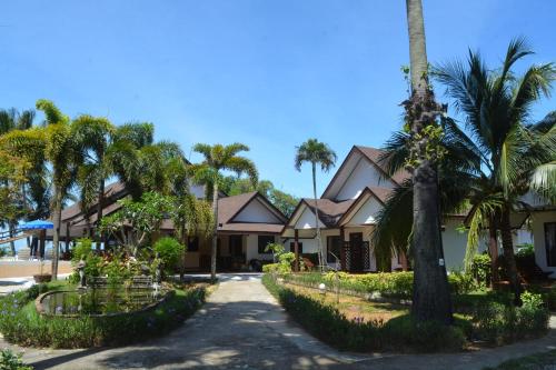a row of houses with palm trees and a driveway at Lanta IL Mare Beach Resort in Ko Lanta