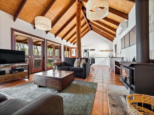 a living room with a couch and a table at Forest Rise Chalets and Lodge in Metricup