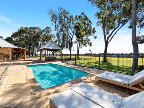 a swimming pool in a yard with a gazebo at Forest Rise Chalets and Lodge in Metricup
